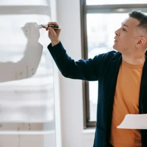 Professional instructor writing on whiteboard in training classroom - general instructor entry level